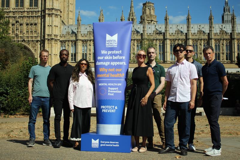 Campaign stunt with giant sunblock tube of mental health SPF: Support Prevention First. Sunblock is outside Parliament, flanked by Mental Health Foundation staff and Young Leaders.